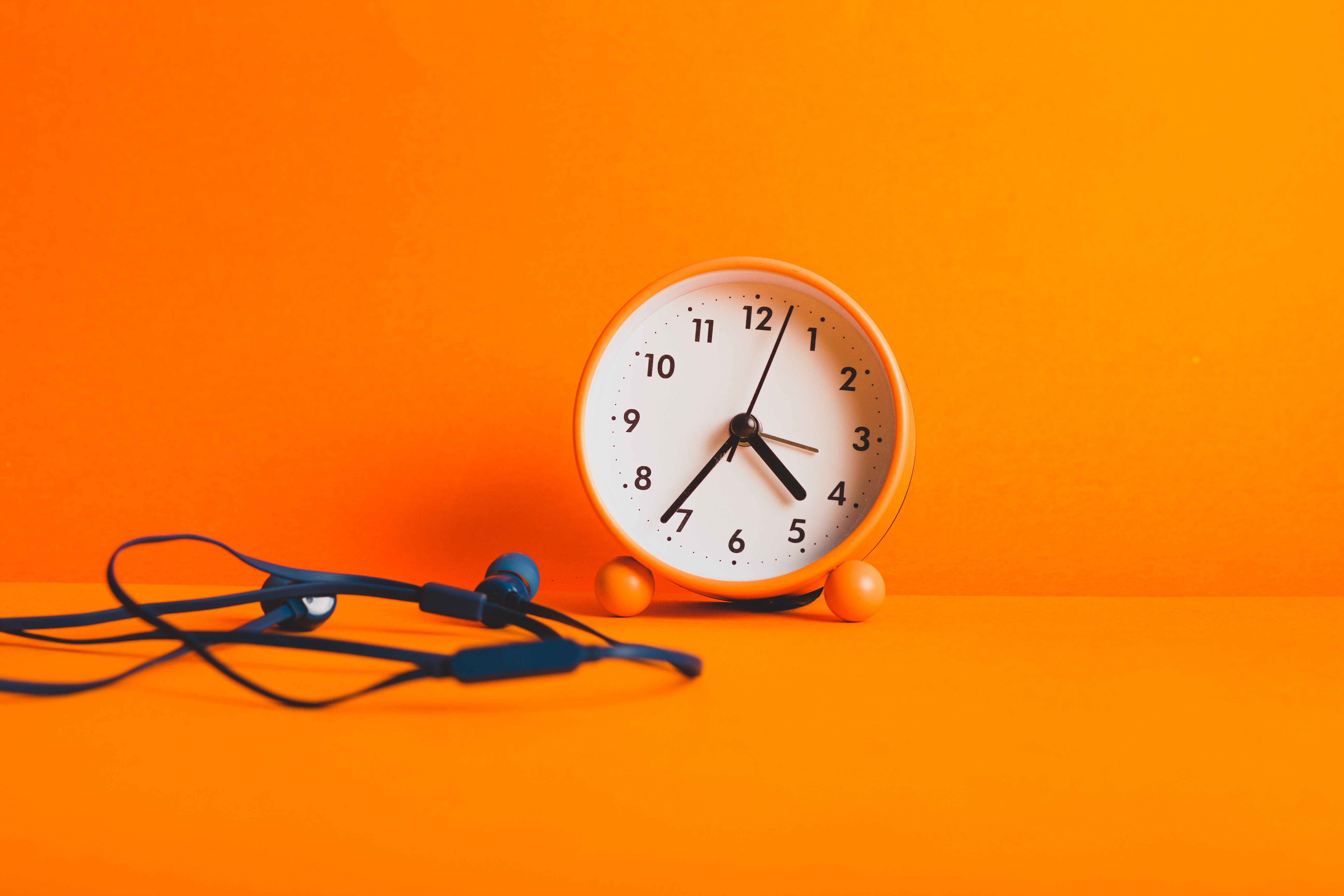 orange clock with headphones
